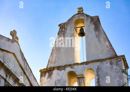 Belfry, campanile di una chiesa ortodossa in PALIÀ PERITHIA, Corfù più antico del villaggio con edifici abbandonati, rovine di pietra costruire case. Foto Stock