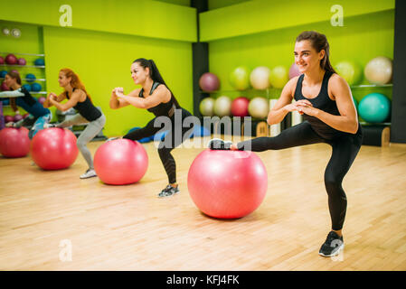 Gruppo di donne con grandi sfere, montare esercizio in motion, allenamento fitness. sport femminile il lavoro di squadra in palestra. classe di aerobica Foto Stock