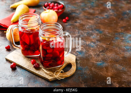 Due vasi di vetro con una bevanda calda fatta da mirtilli e mele con spezie, vin brulé, punch o grog. Foto Stock