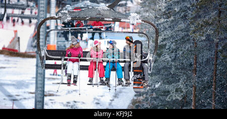 Le persone sono il sollevamento su ski-lift per sciare in montagna Foto Stock