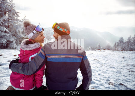 Coppia giovane in amore godendo per le vacanze invernali insieme sulla montagna Foto Stock