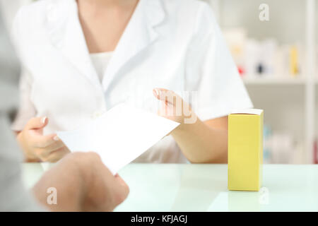 Close up di un cliente dando la ricetta di un farmacista la richiesta di medicine in farmacia interno Foto Stock