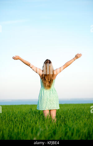 La felicità della donna soggiorno all'aperto sotto la luce del sole del tramonto Foto Stock