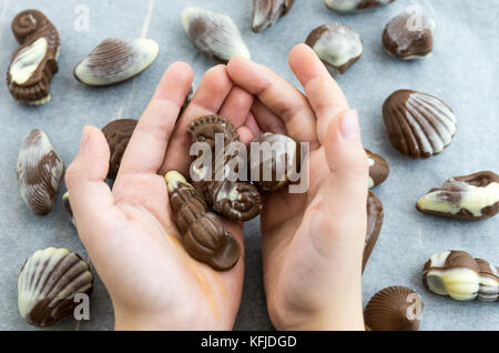 Un uomo è in possesso di cioccolatini. Sfondo bianco. Foto Stock