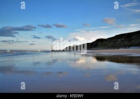 Spiaggia di Norfolk con Cielo e nubi riflessi nella sabbia bagnata sulla riva Foto Stock