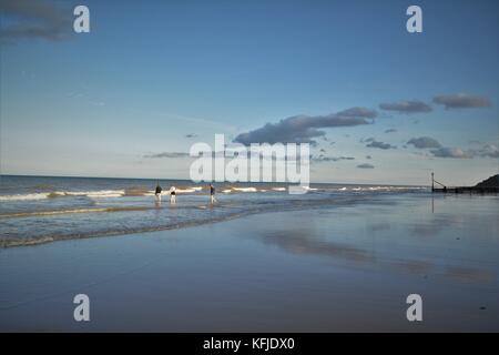 Spiaggia di Norfolk con Cielo e nubi riflessi nella sabbia bagnata sulla riva Foto Stock