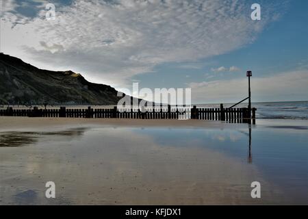 Spiaggia di Norfolk con Cielo e nubi riflessi nella sabbia bagnata sulla riva Foto Stock