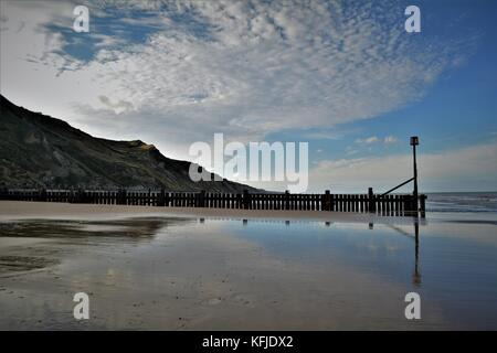 Spiaggia di Norfolk con Cielo e nubi riflessi nella sabbia bagnata sulla riva Foto Stock