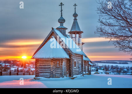 Piccola chiesa russa al tramonto in inverno Foto Stock