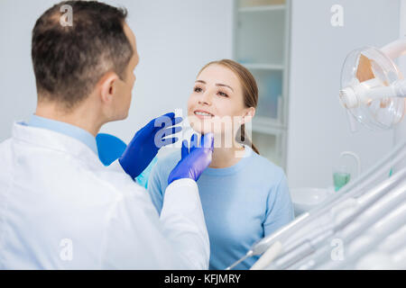 Bella donna piacevole guardando il suo medico Foto Stock