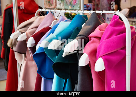 Cashmere tessuti colorati abiti simili su appendiabiti in negozio Foto Stock
