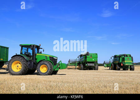 Salo, Finlandia - agosto 21, 2015: John Deere 7280r il trattore e mietitrebbia sul campo in corrispondenza di impostare puontin peltopaivat raccolta agricola Foto Stock