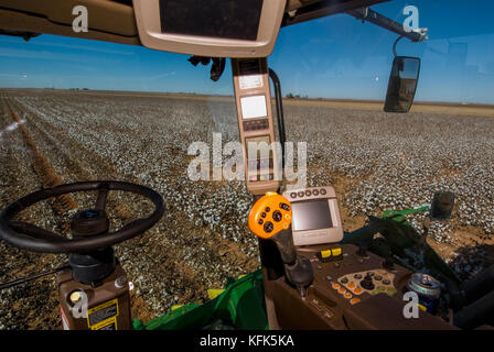 Nuovo trattore John Deere 6 fila raccoglitrice di cotone che rende i moduli rotondo nel campo mentre in fase di sviluppo che mostra il monitor di controllo di resa e sistema gps e controlli Foto Stock