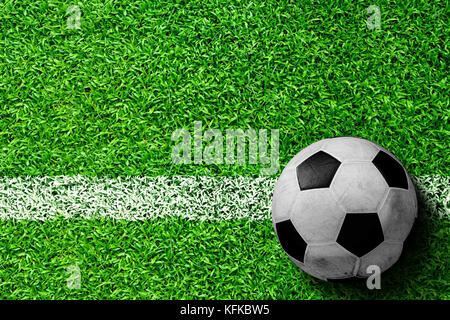 Pallone da calcio sul campo con la linea bianca marcatura pronto per l'azione. linea rappresenta il calcio di inizio o emarginare per gettare. copia di spazio. Foto Stock