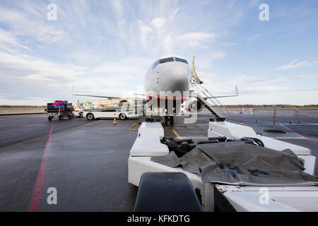 Carrello di traino con aereo commerciale sulla pista di aeroporto Foto Stock