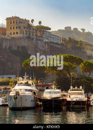 Barche ormeggiate a Marina piccola con alberghi in cima alla scogliera sullo sfondo. Sorrento, Italia. Foto Stock