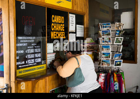 La Seychelles, Praslin, Baie St Anne Jetty, sovrappeso tourist cambiare denaro presso lo stand di exchange Foto Stock