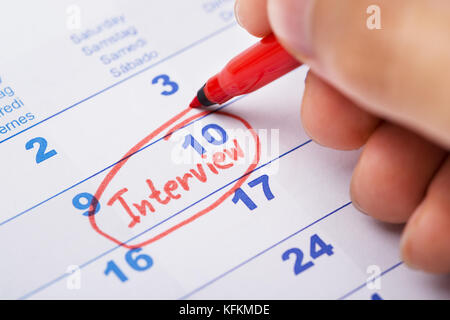 Immagine ritagliata della mano intervista di marcatura sul calendario Foto Stock