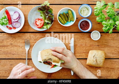 Prendendo il primo boccone fuori del self made sandwich deliziosi snack buongustai Foto Stock