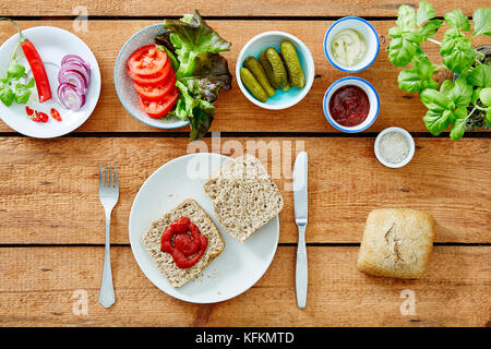 Preparare un panino vegano tomatoe mettendo in salsa di bredrole Foto Stock