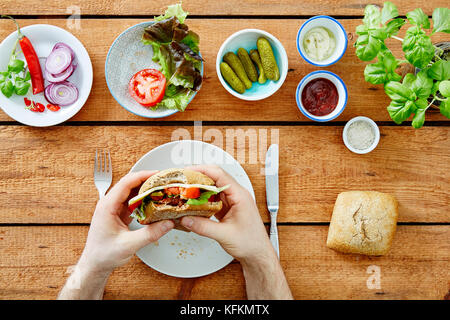 Persona prendendo il primo boccone fuori di buongustai snack Foto Stock