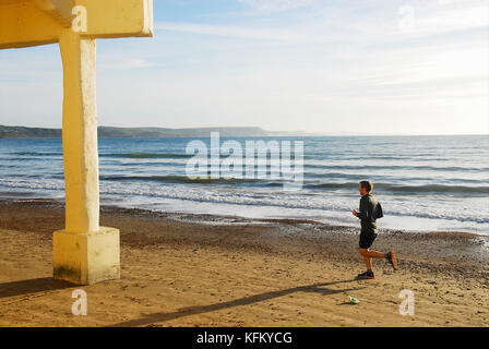 Weymouth, Regno Unito. 30 ott 2017. uk meteo. un soleggiato ma freddino per iniziare la giornata a Weymouth e un uomo gode di un inizio di mattina correre lungo la spiaggia credito: stuart fretwell/alamy live news Foto Stock