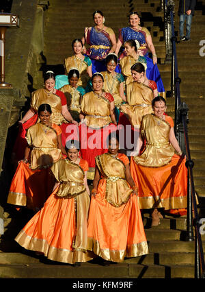 Un gruppo di danzatori indiani a piedi giù i passaggi in Princes Street Gardens per eseguire l'annuale Diwali Festival di Edimburgo. Foto Stock