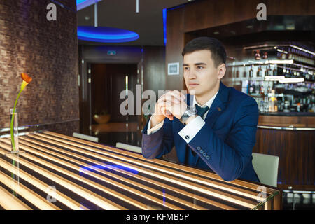 Lo sposo seduti a tavola in un bar e in attesa per la sua sposa Foto Stock