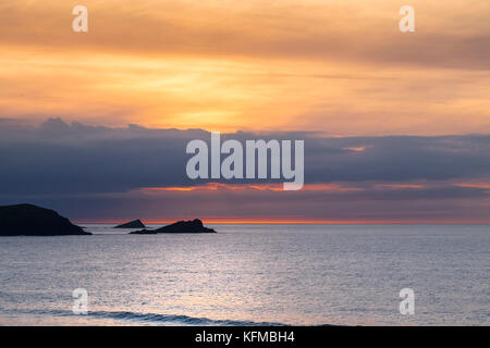 Tramonto spettacolare - l'oca e il pulcino di piccole isole al largo di Oriente Pentire Headland seeen sono in silhouette come il sole tramonta su Fistral in Cornovaglia. Foto Stock