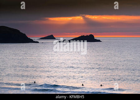 Tramonto spettacolare - l'oca e il pulcino di piccole isole al largo di Oriente Pentire Headland seeen sono in silhouette come il sole tramonta su Fistral in Cornovaglia. Foto Stock