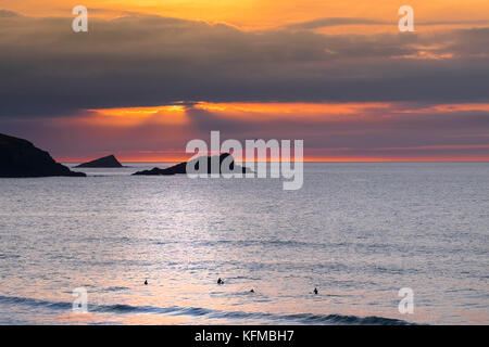 Tramonto spettacolare - l'oca e il pulcino di piccole isole al largo di Oriente Pentire Headland seeen sono in silhouette come il sole tramonta su Fistral in Cornovaglia. Foto Stock