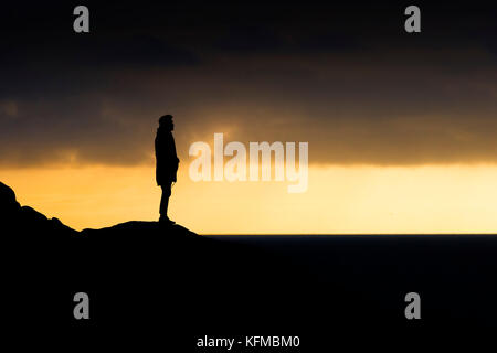 Silhouette - un uomo solitario stagliano contro la luce della sera. Foto Stock