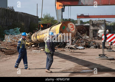 Il tubo offshore fuori servizio viene sollevato da una gru nel deposito di rottami metallici dopo la consegna con camion dai bacini di Great Yarmouth. Foto Stock