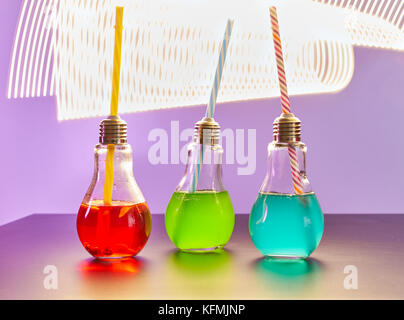 Tre cocktail colorati per party in luce a forma di bulbo bicchieri. Foto Stock