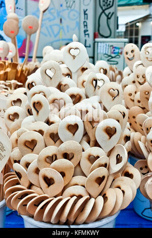 Cucchiai in legno con forma a cuore intagliato in esposizione in una bancarella al mercato. Pila di utensili da cucina organici artigianali, primo piano, dettaglio. Vienna. Foto Stock