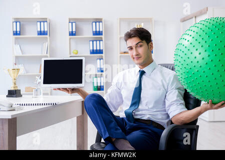Giovane imprenditore facendo sport stretching al lavoro Foto Stock