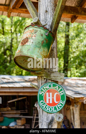 Un vecchio antichi verde benzina può appeso accanto a un segno per sinclair hc benzina nelle zone rurali di Alabama, Stati Uniti d'America. Foto Stock