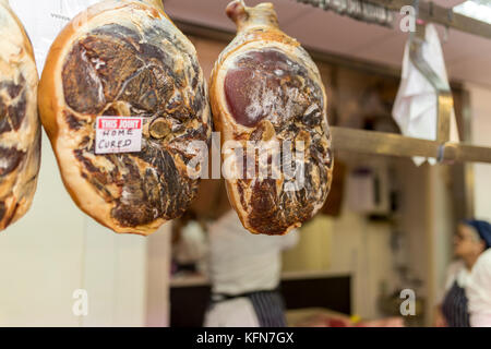 Scelta e home premium indurito giunti di maiale appeso in un negozio di macellaio su un mercato in stallo in Inghilterra, Regno Unito Foto Stock