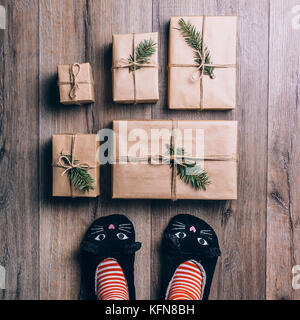 Piedi con il caldo inverno calze in piedi di fronte a Doni di natale Foto Stock
