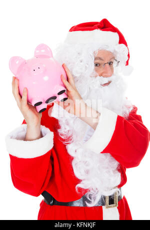 Santa holding salvadanaio su sfondo bianco Foto Stock