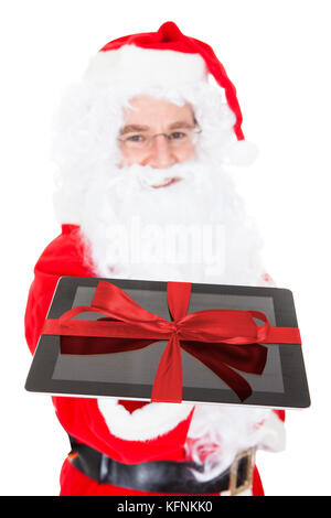 Santa holding tavoletta digitale su sfondo bianco Foto Stock