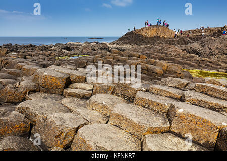 Migliaia di turisti visitano Giant's Causeway nella contea di Antrim in Irlanda del Nord, un sito del patrimonio culturale mondiale dell UNESCO contenente circa 40000 interlock Foto Stock