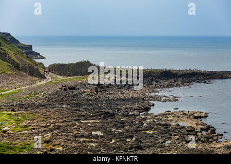 Migliaia di turisti visitano Giant's Causeway nella contea di Antrim in Irlanda del Nord, un sito del patrimonio culturale mondiale dell UNESCO contenente circa 40000 interlock Foto Stock