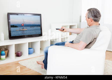 Ritratto di un uomo maturo di guardare la tv a casa Foto Stock