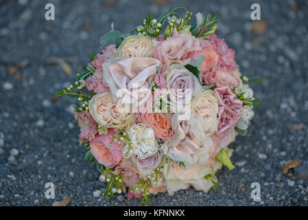 Rose e peonie e la seta in un delicato, pastello, dusky rosa bouquet nuziale Foto Stock