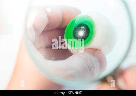 Esame di un silicone replica di un occhio con lente di ingrandimento Foto Stock