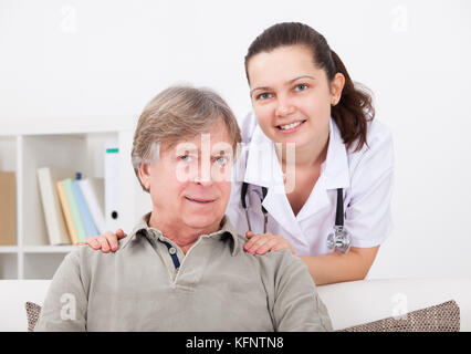 Ritratto di felice medico donna con paziente maturo Foto Stock