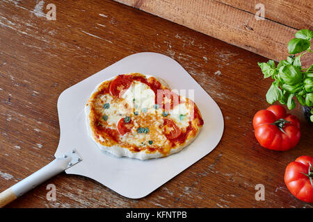 Pizza Margherita sulla pala in classic pizzeria Foto Stock