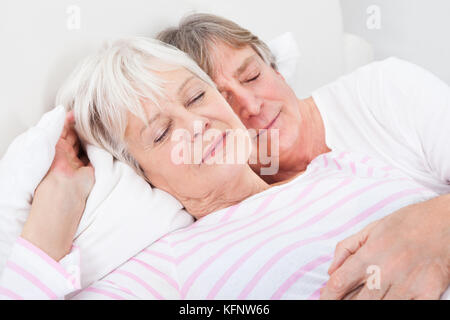Ritratto di amorevole coppia Senior giacente sul letto Foto Stock