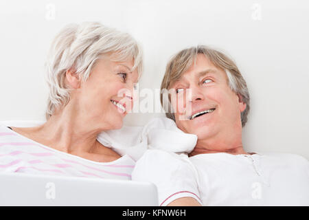 Ritratto di amorevole coppia Senior giacente sul letto Foto Stock